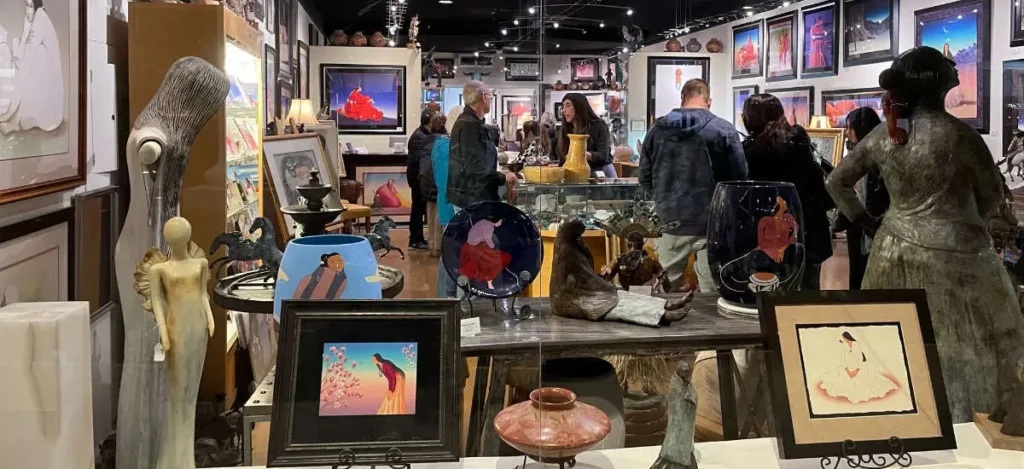 Visitors explore framed artwork, ceramics and sculptures inside R.C. Gorman Navajo Gallery.