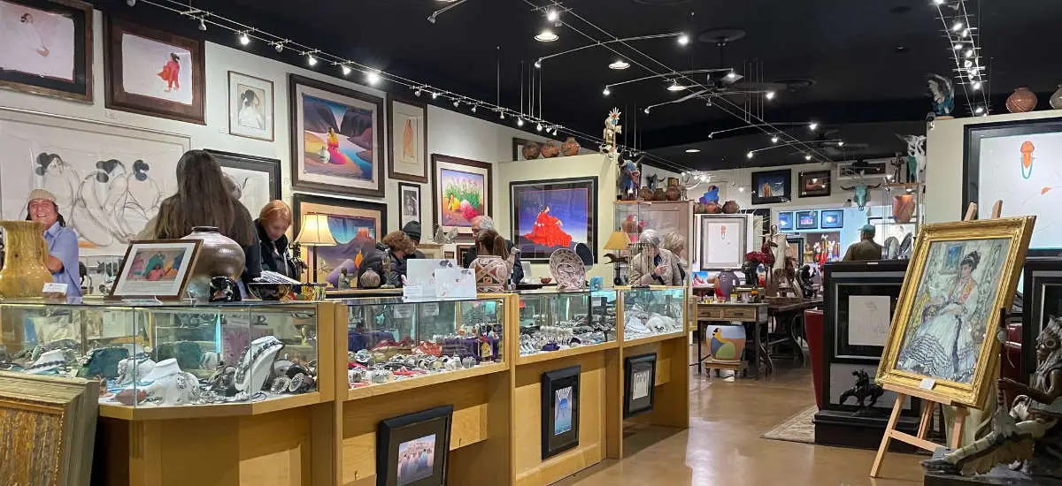 Visitors browse artwork and glass display cases inside the Scottsdale gallery.